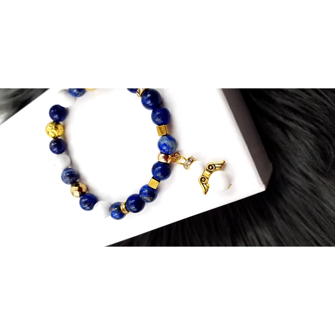 "Kék angyal" kristálykarkötő.  Howlit, arany hematit, és lazurit ásványokbóll készült karkötő, arany szín díszítéssel és egy angyal medállal.